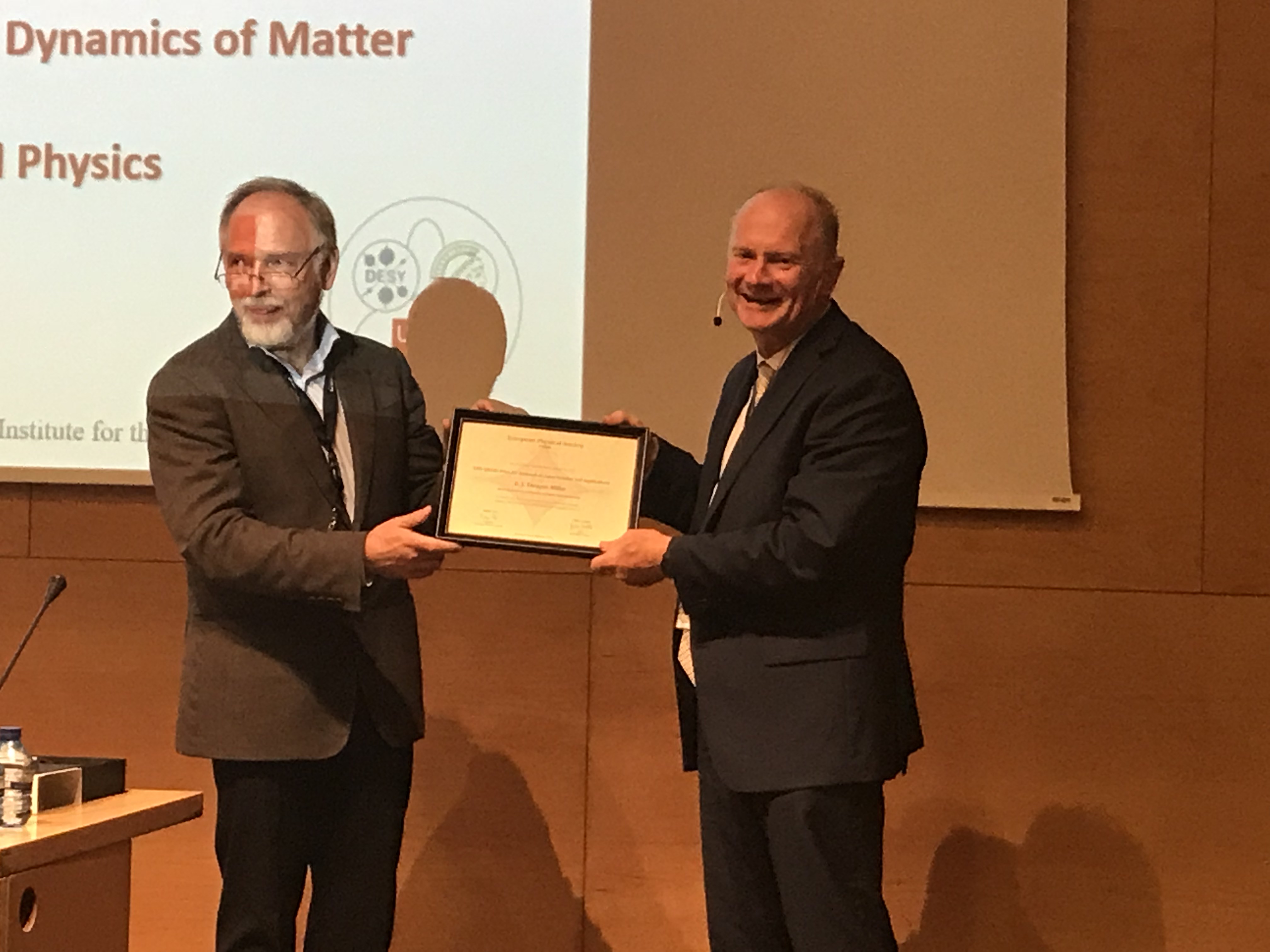 R. J. Dwayne Miller receiving the 2018 prize for research in laser science and applications from Valdas Pasiskevicius